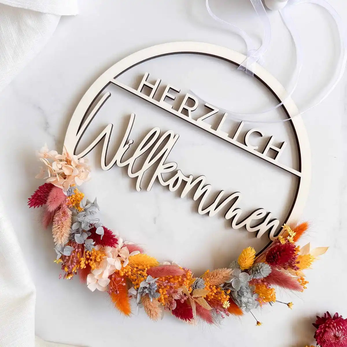 Trockenblumen-Türkranz Flores in Orange und Rot mit Schriftzug Herzlich Willkommen